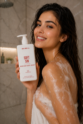 Woman in the shower holding Babell Soft Sin perfume body wash, 250ml.
